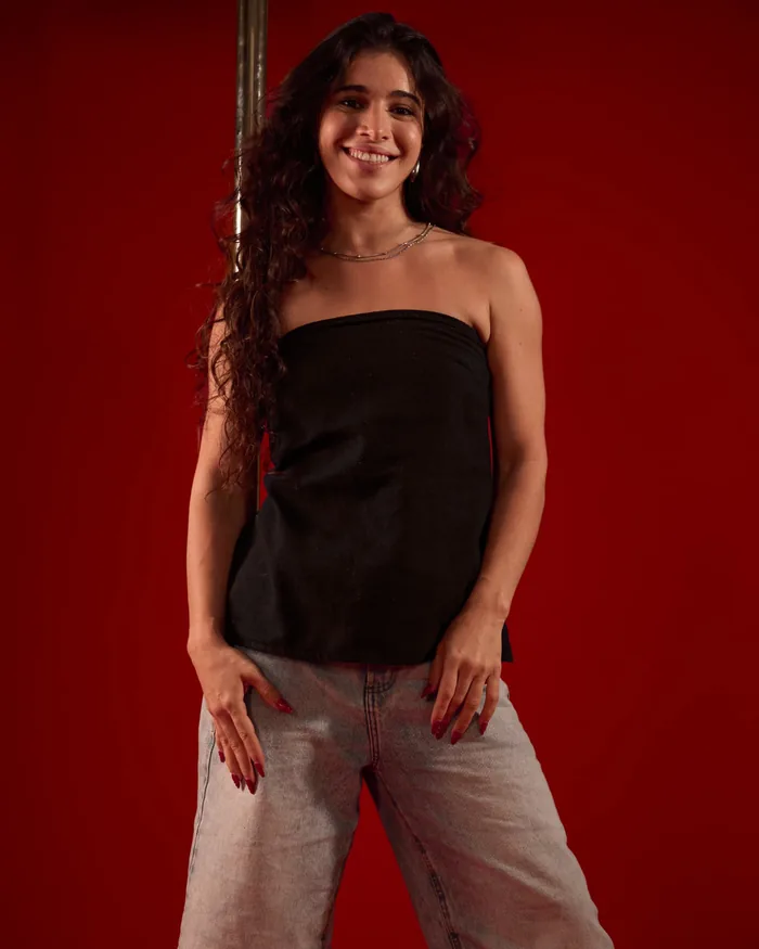 Foto de Roberta Martins em estúdio com fundo vermelho